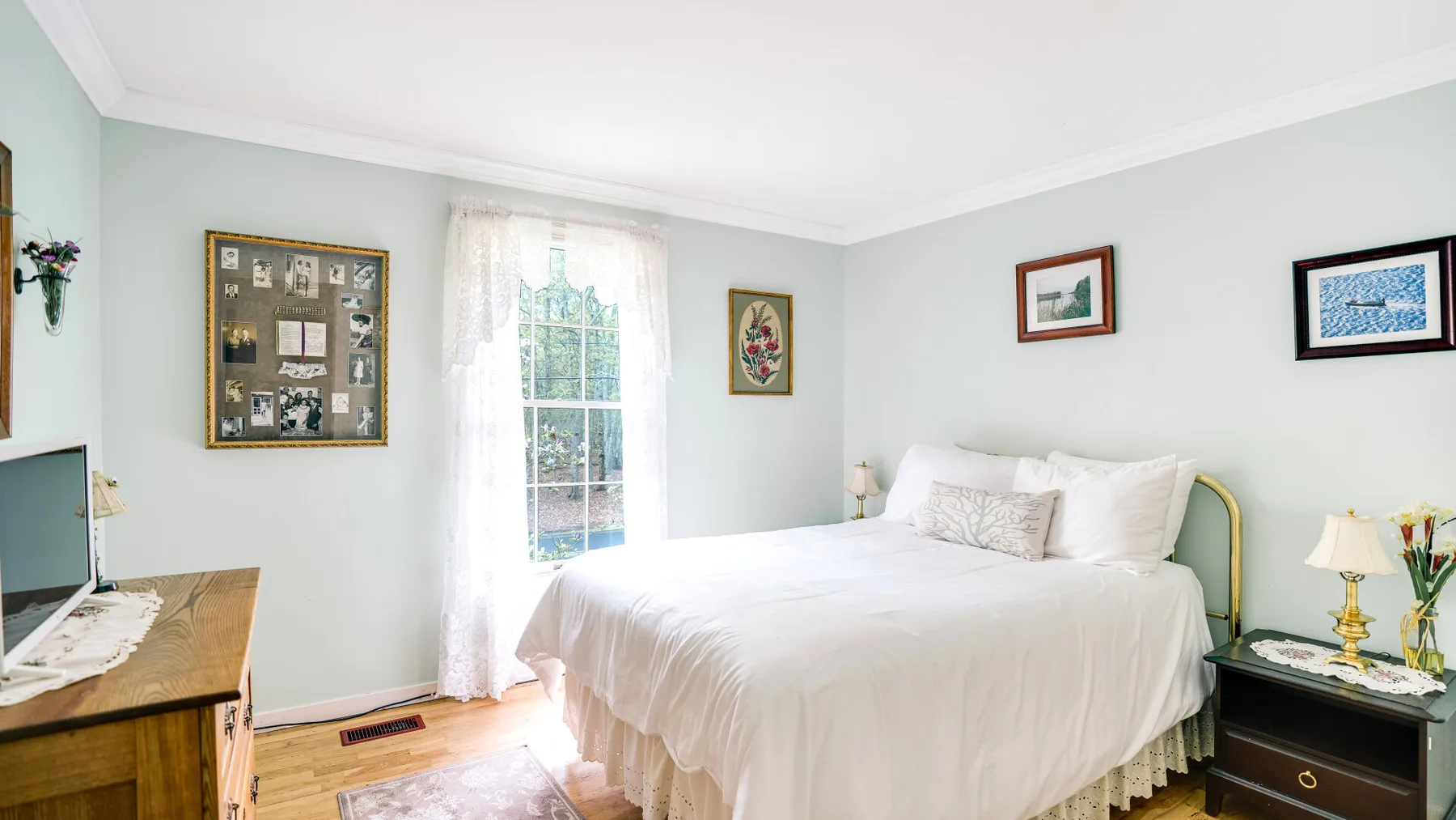 Bedroom with a white bed beside a tall window.