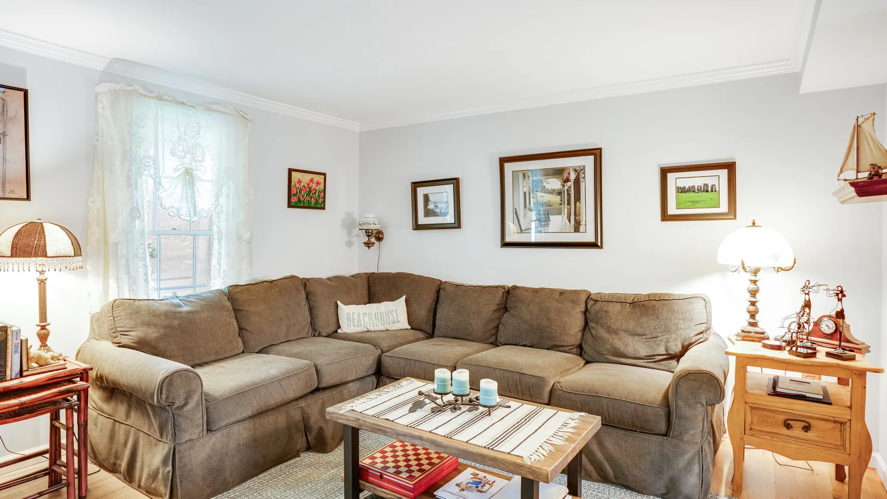 A living room with sectional seating, a coffee table, and framed artwork.