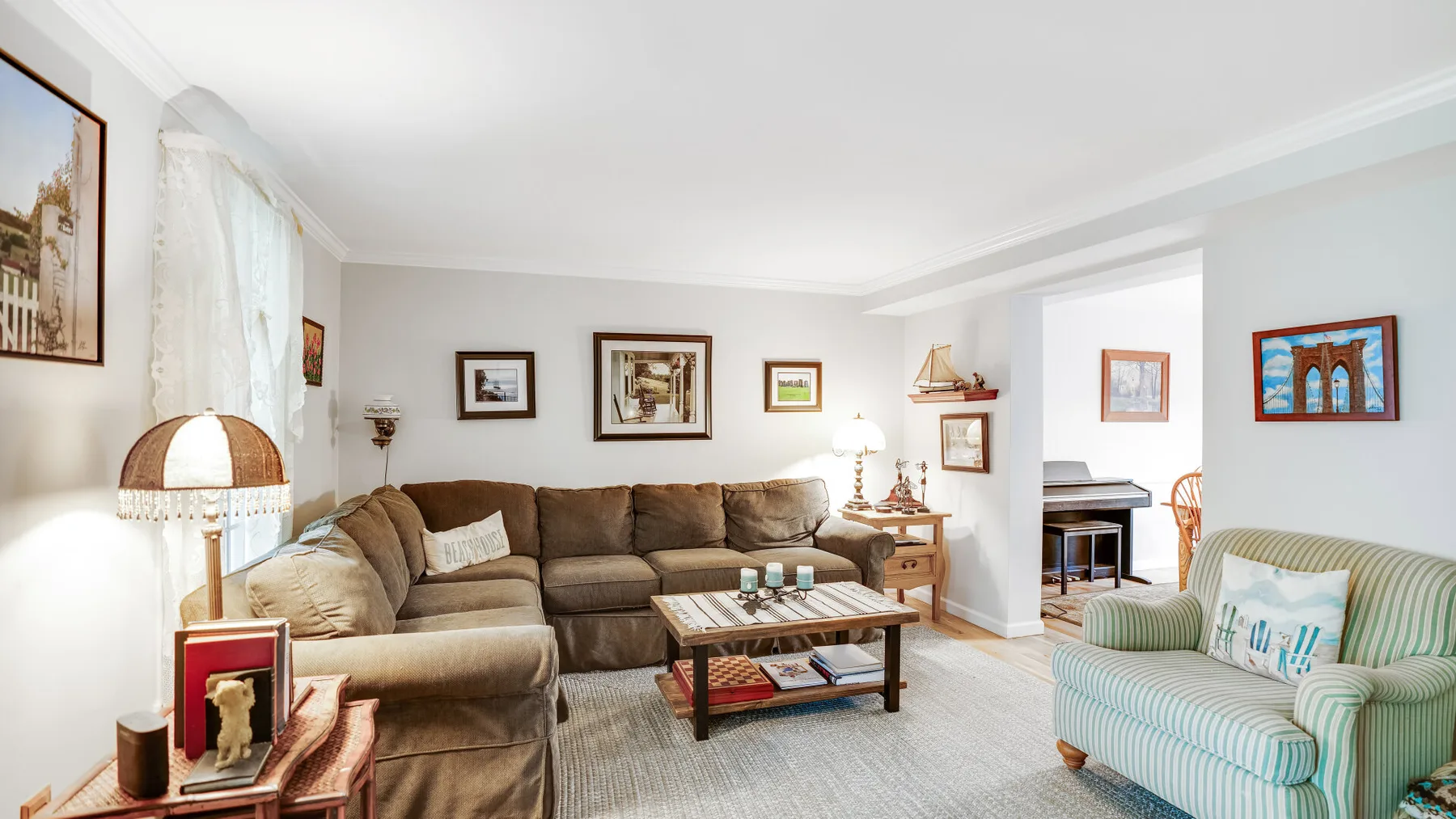 A living room with a sectional sofa, coffee table, and striped armchair.