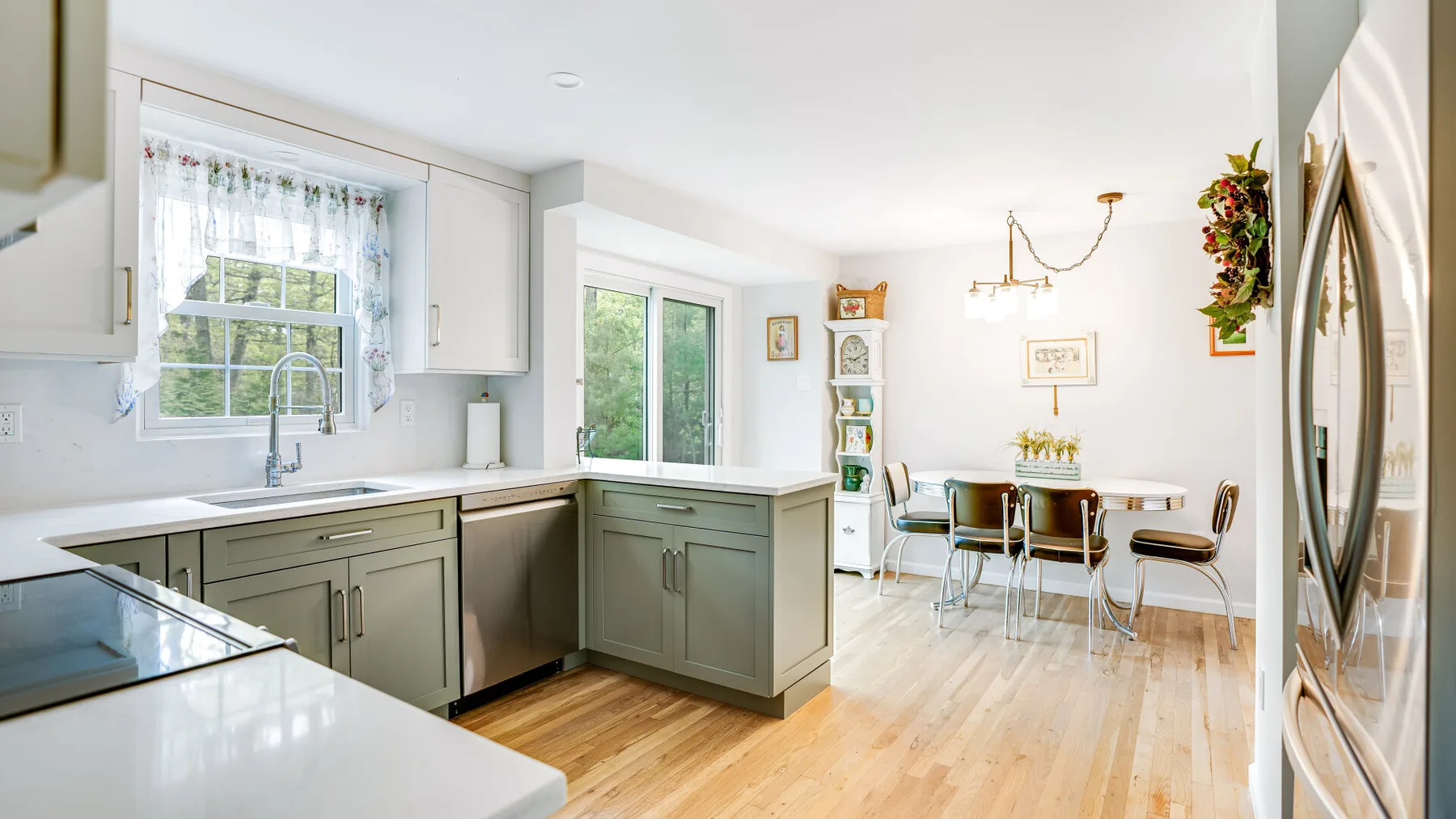 A bright kitchen with a dining table and chairs beside the cabinets.