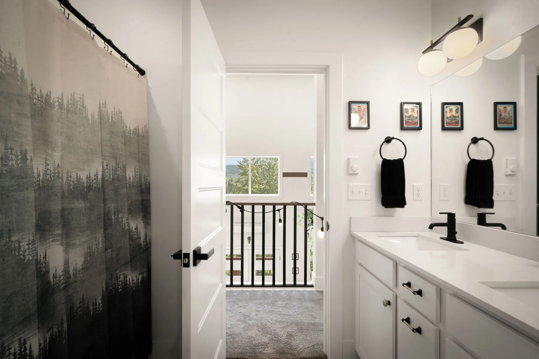 Un tocador y lavabo de baño dan a una puerta abierta con vista a un rellano interior iluminado.