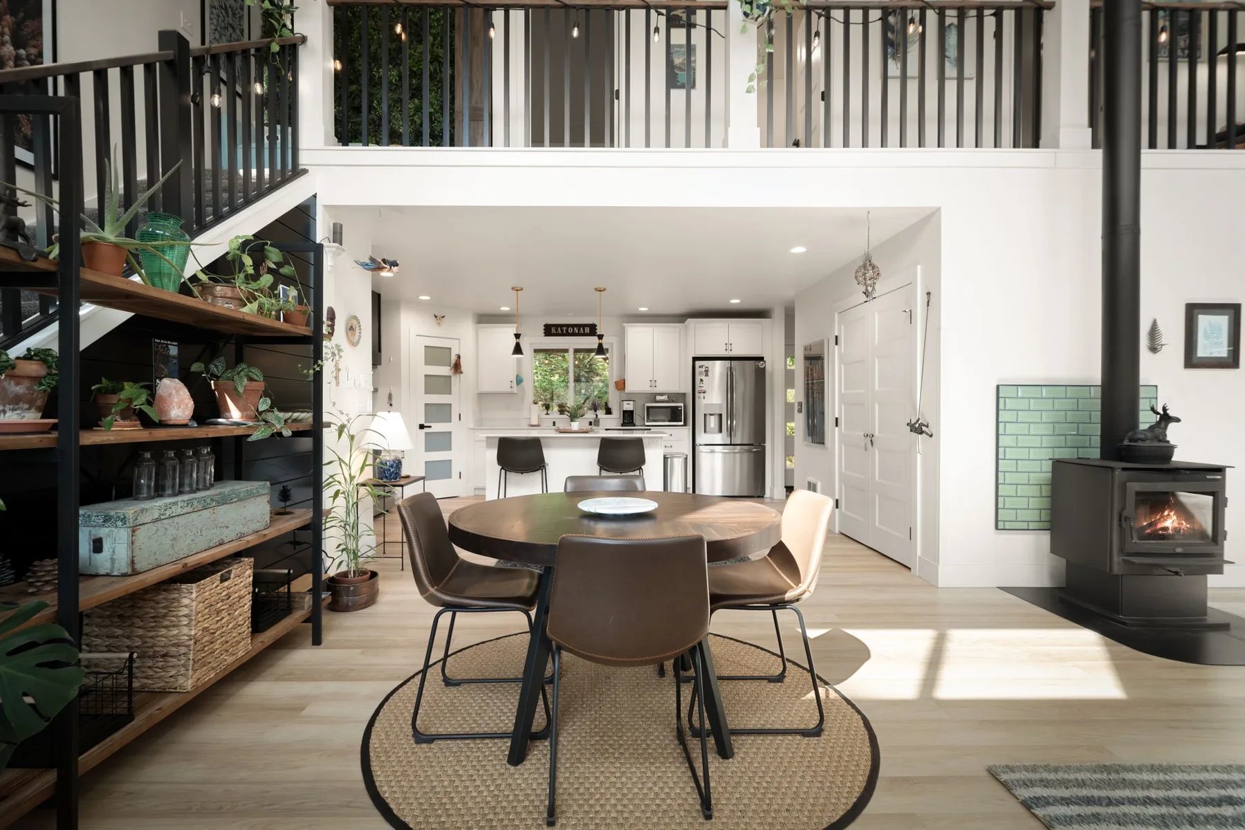 Una zona diáfana de comedor y cocina cuenta con una mesa redonda y una chimenea.