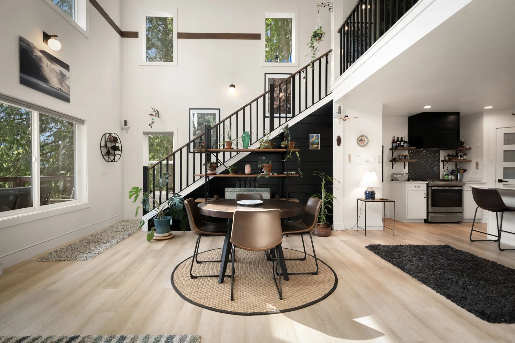 Una luminosa sala-comedor de concepto abierto con una escalera y cocina.