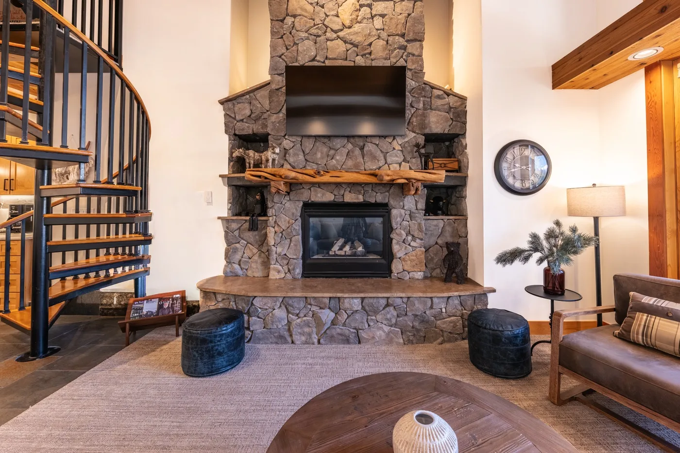 A living room with a stone fireplace, television, and seating.