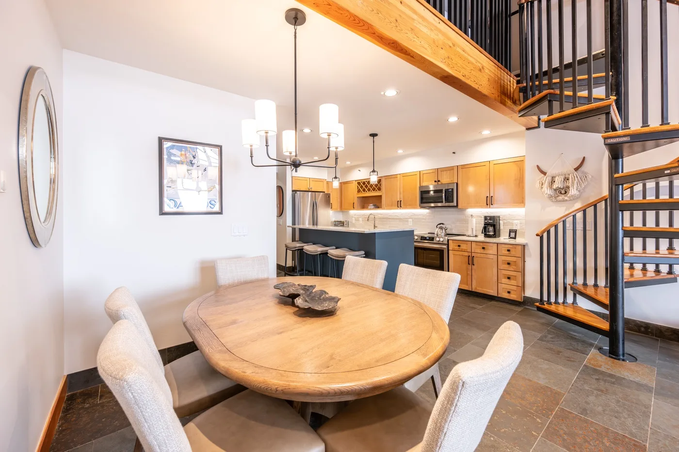 An open dining and kitchen area with a wooden table and a staircase.