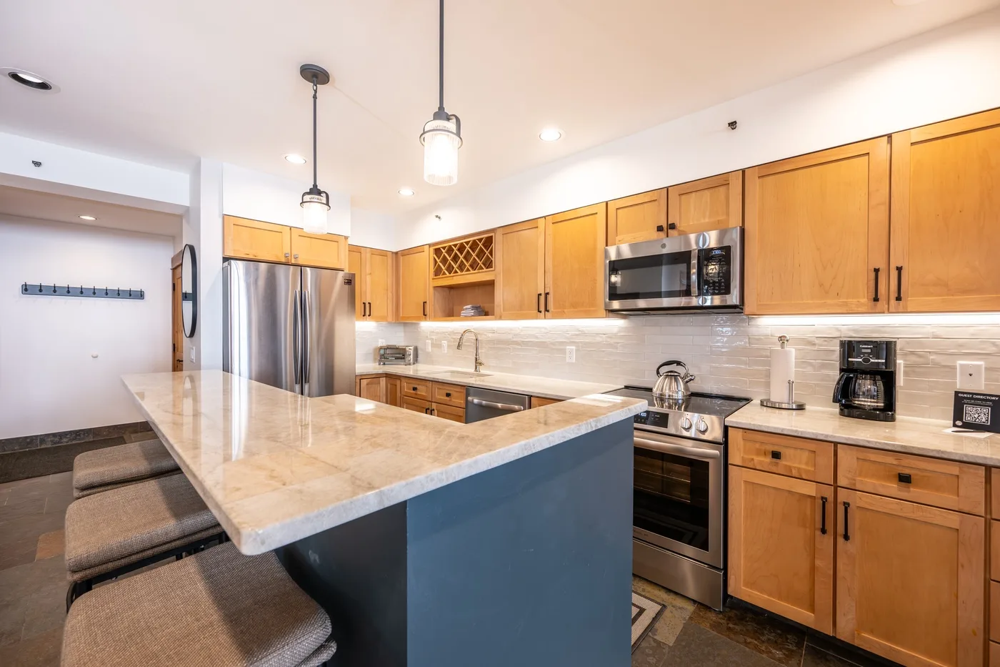 A kitchen with wooden cabinets, stainless steel appliances, and a large island.