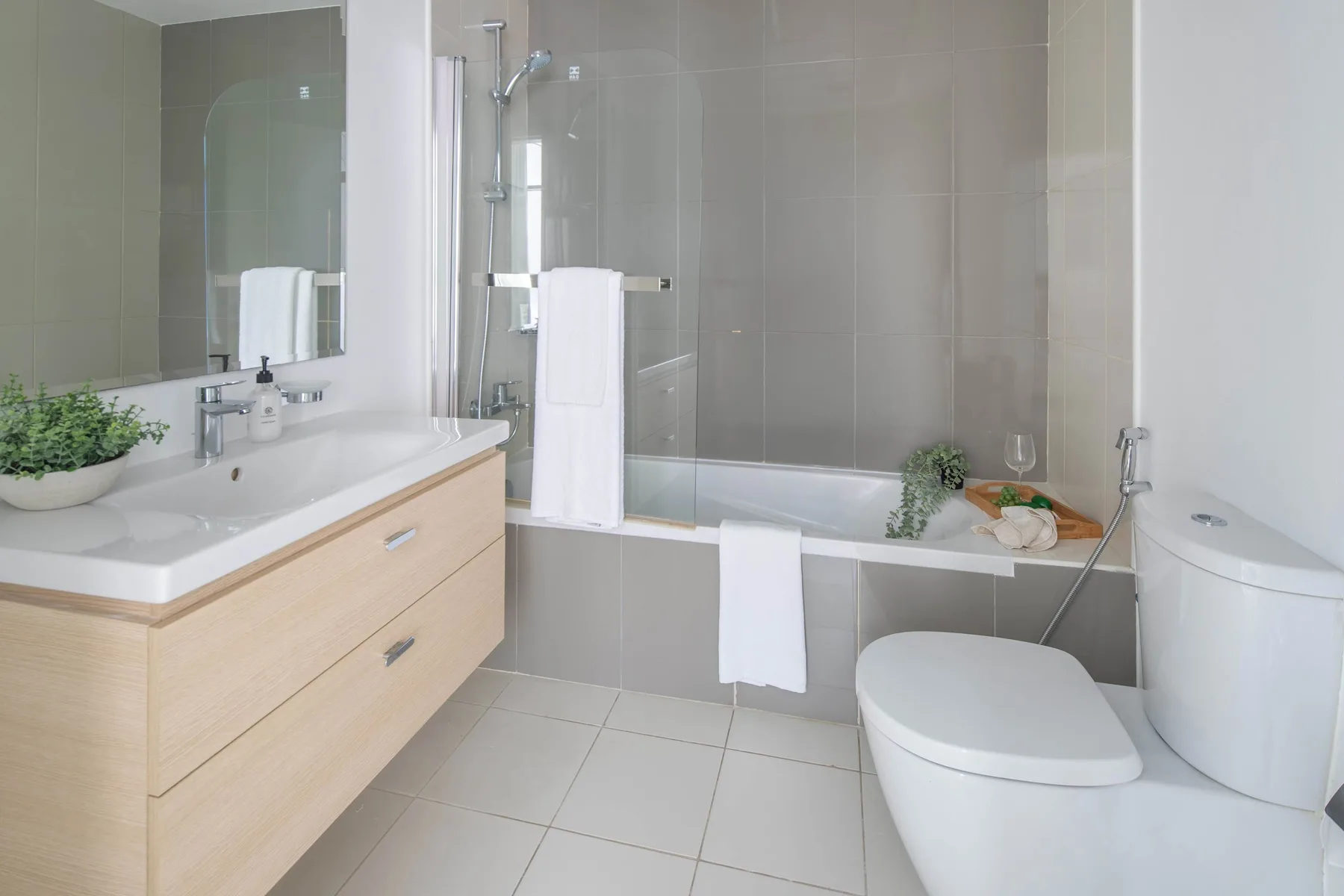 Un baño luminoso con bañera, lavabo e inodoro.
