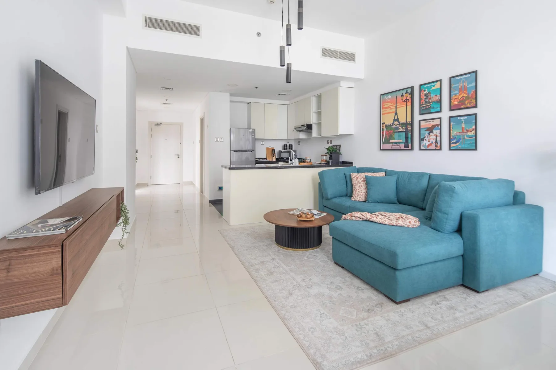 Sala de estar con sofá azul y cocina abierta.