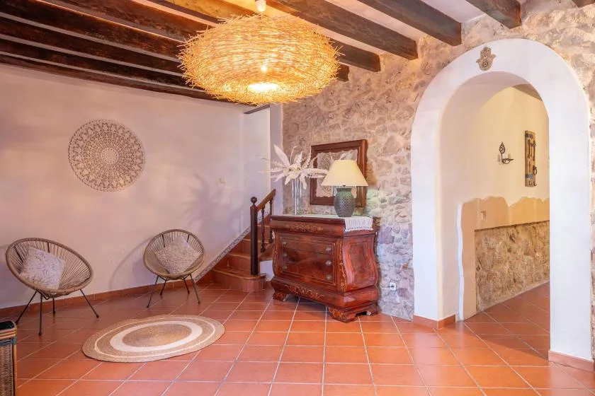 A tiled interior room with wooden ceiling beams and a decorative hanging light.