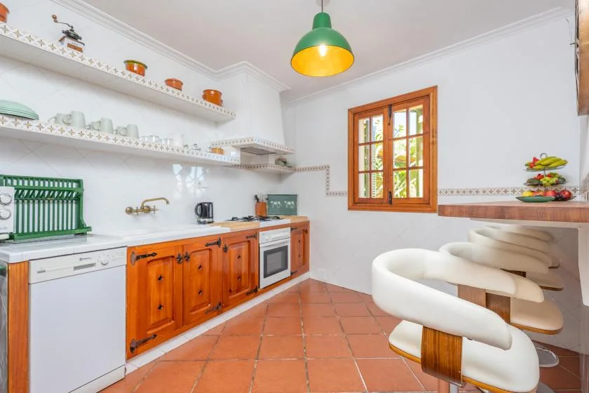 A bright kitchen with wooden cabinets, open shelves, and a window.