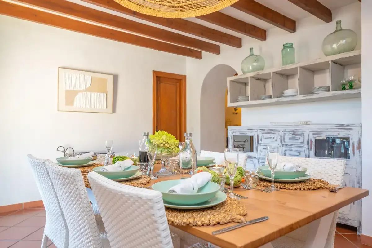 A dining area with a set table, woven placemats, and white seating.