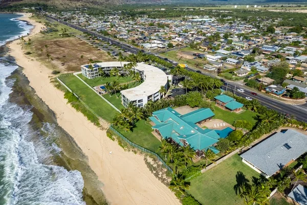 Vista aérea de un complejo costero junto a una playa de arena y el océano.