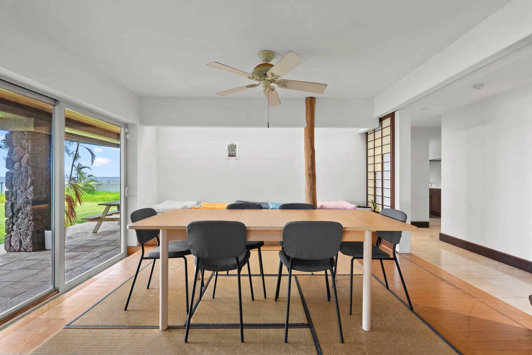 Un comedor luminoso con una mesa larga y puertas corredizas de vidrio que dan a un patio.