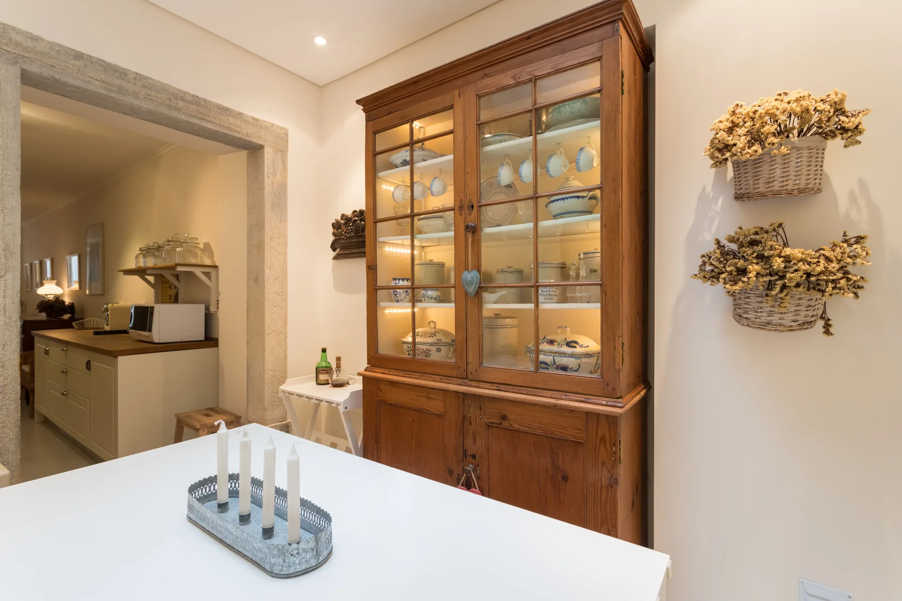 A dining area features a wooden display cabinet filled with dishes.