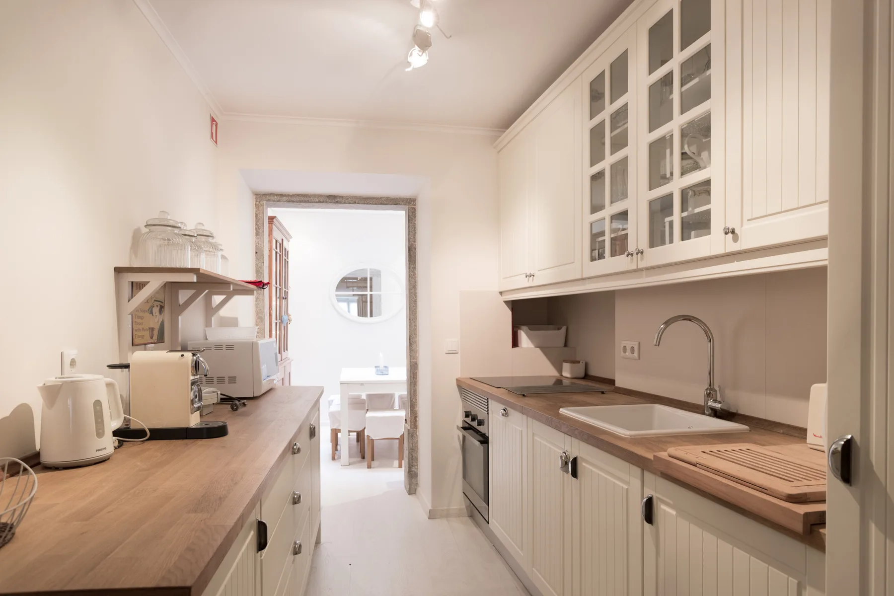 A bright kitchen with wooden countertops and white cabinets.