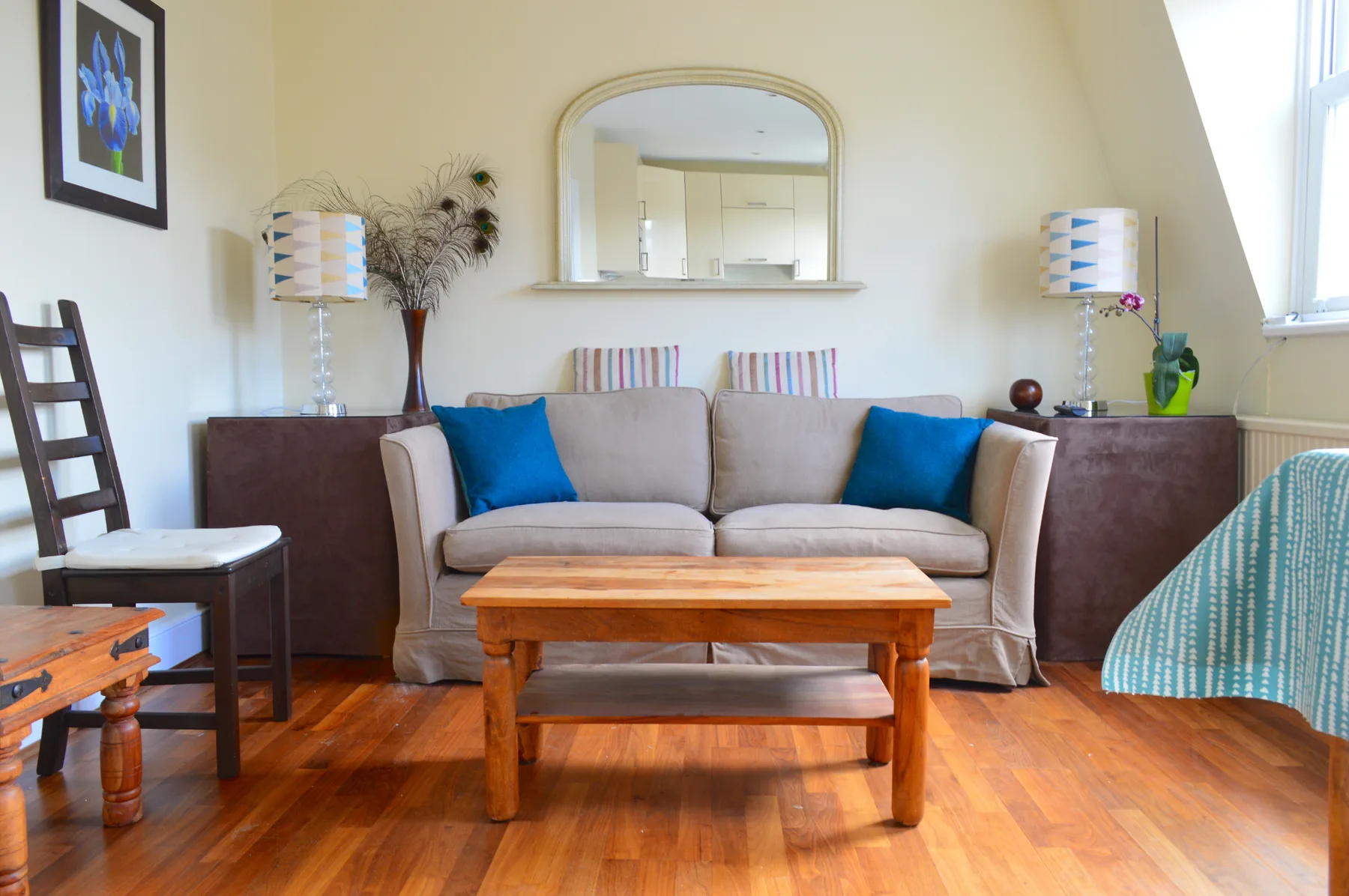 A living room with a sofa, blue cushions, and a wooden coffee table.
