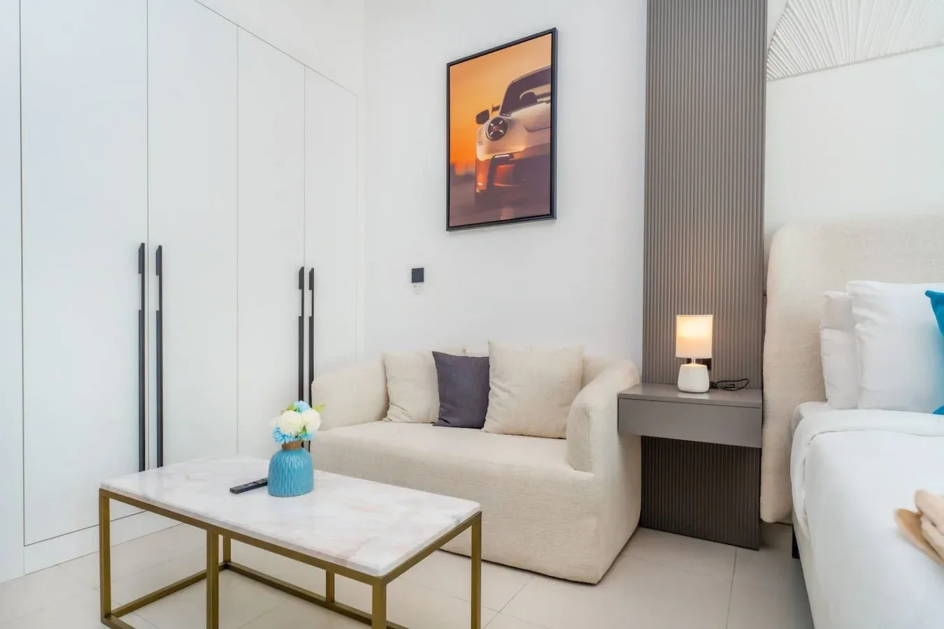 Una luminosa zona de estar en el dormitorio, con sofá crema y mesa auxiliar.