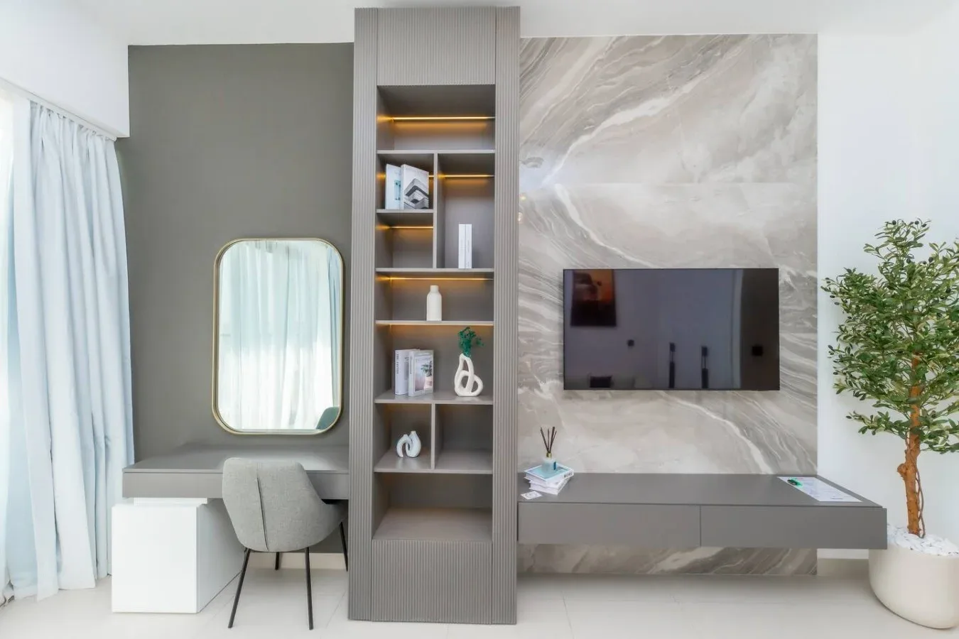 Una sala de estar moderna con un televisor de pared y estanterías empotradas.