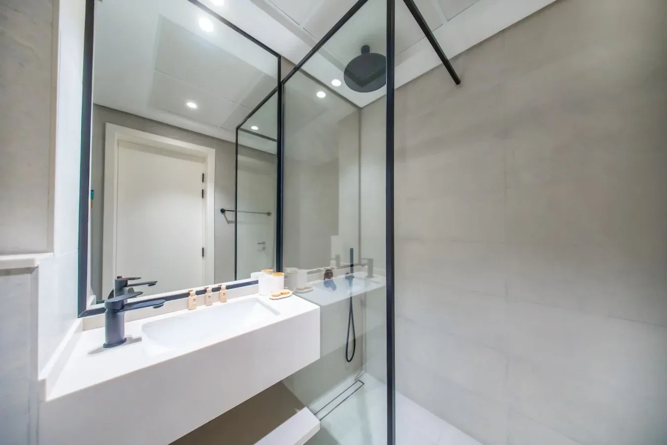 Un baño moderno con un lavabo amplio y una ducha de vidrio.