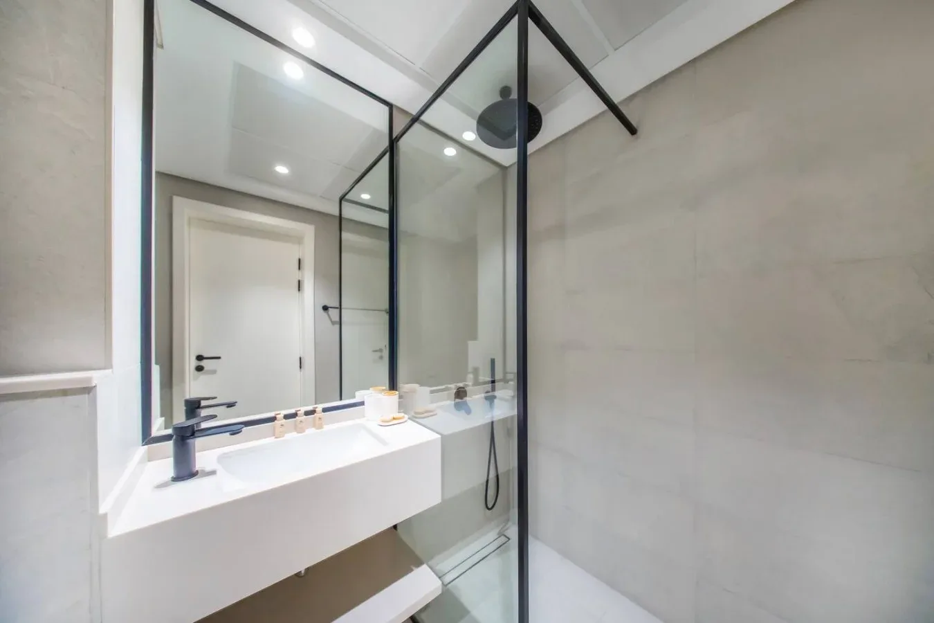 Un baño moderno con lavabo suspendido y ducha de cristal.