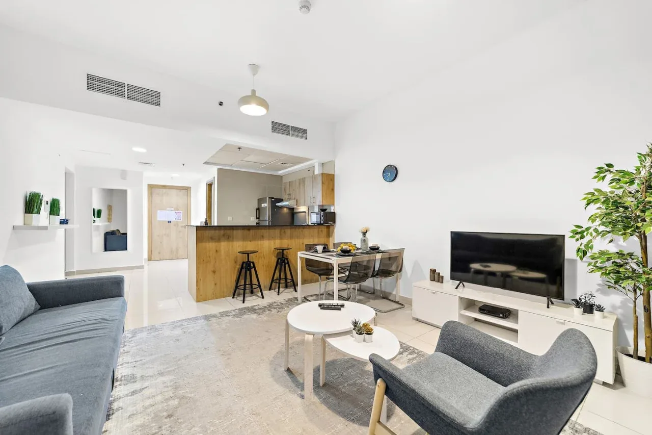 Una sala luminosa se abre a una cocina y un comedor.