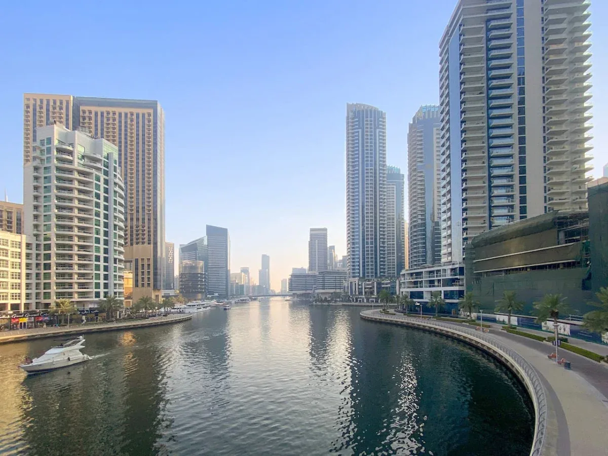 Un canal serpentea entre edificios altos, con un paseo junto al agua.
