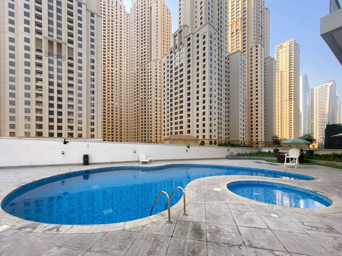 Una piscina al aire libre está rodeada de altas torres residenciales.