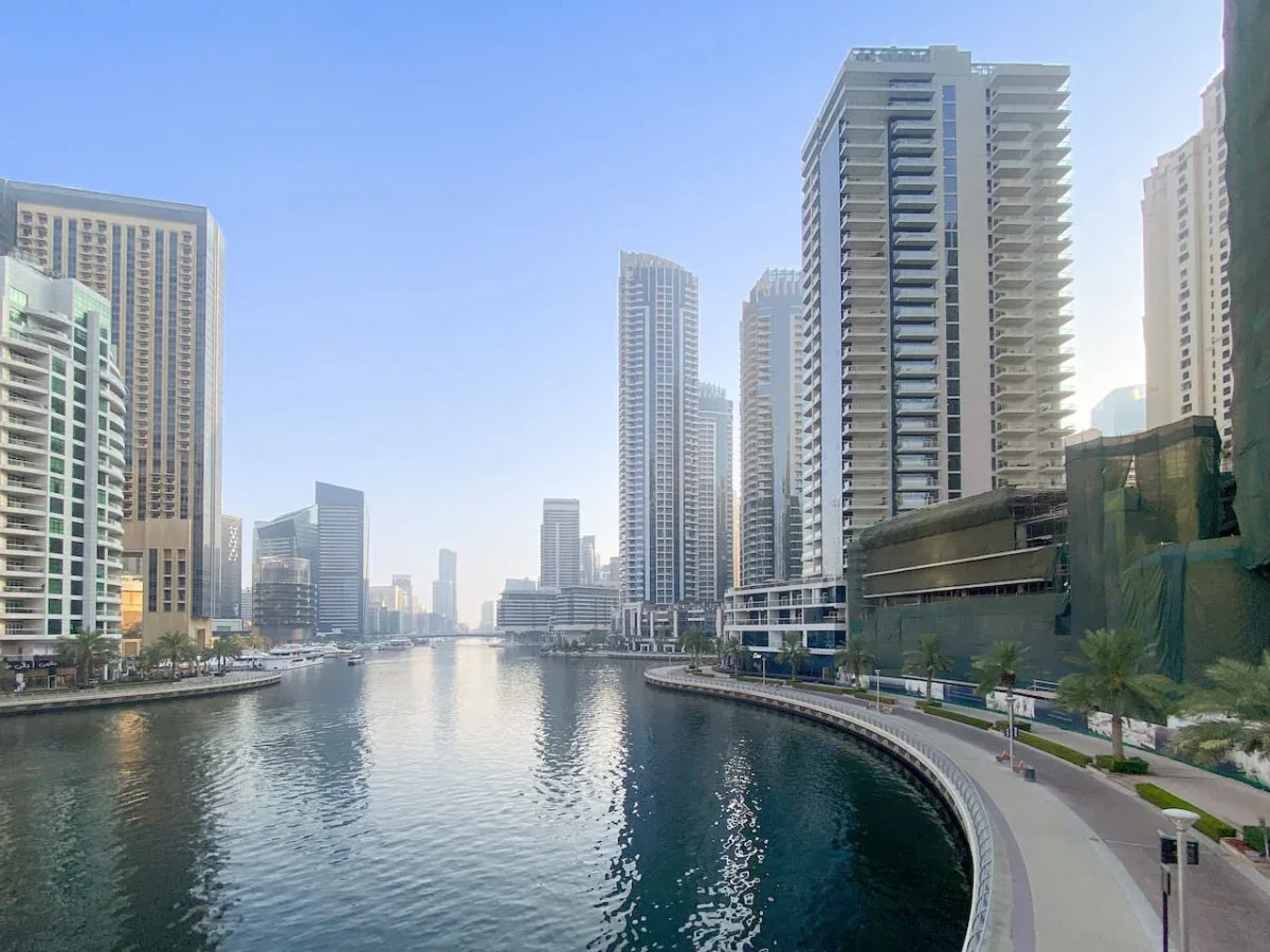Un canal deportivo se curva entre edificios altos y un paseo junto al agua.