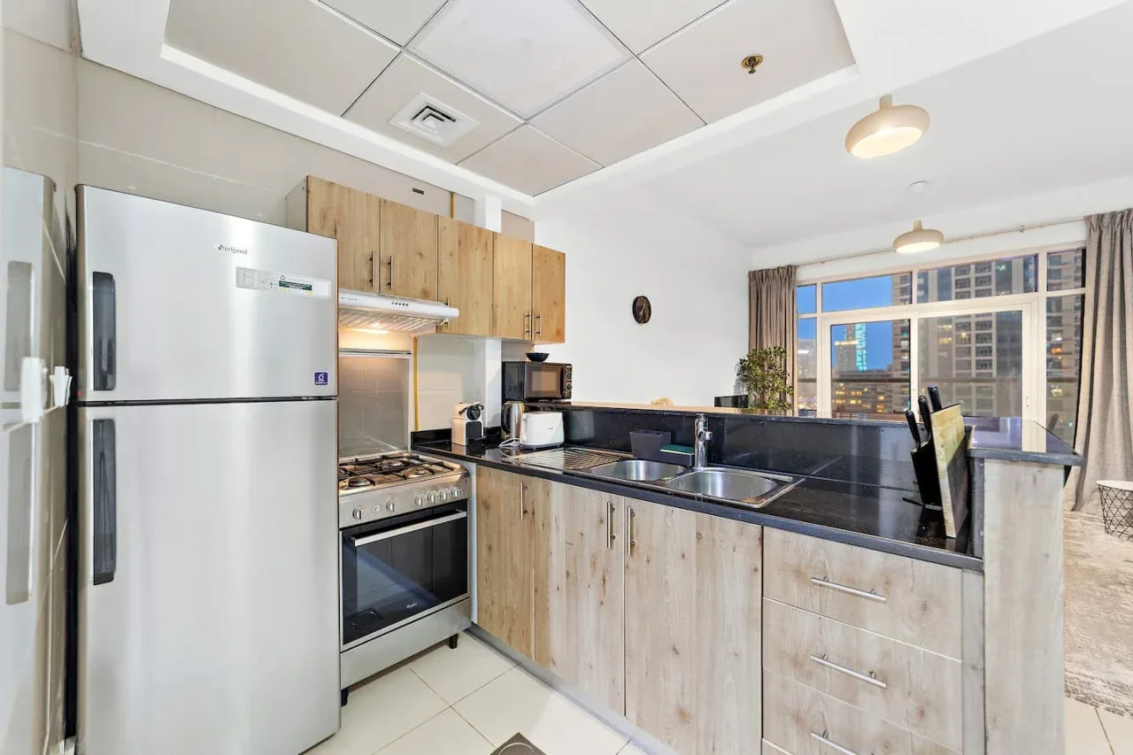 Una cocina con gabinetes de madera clara y una encimera oscura.