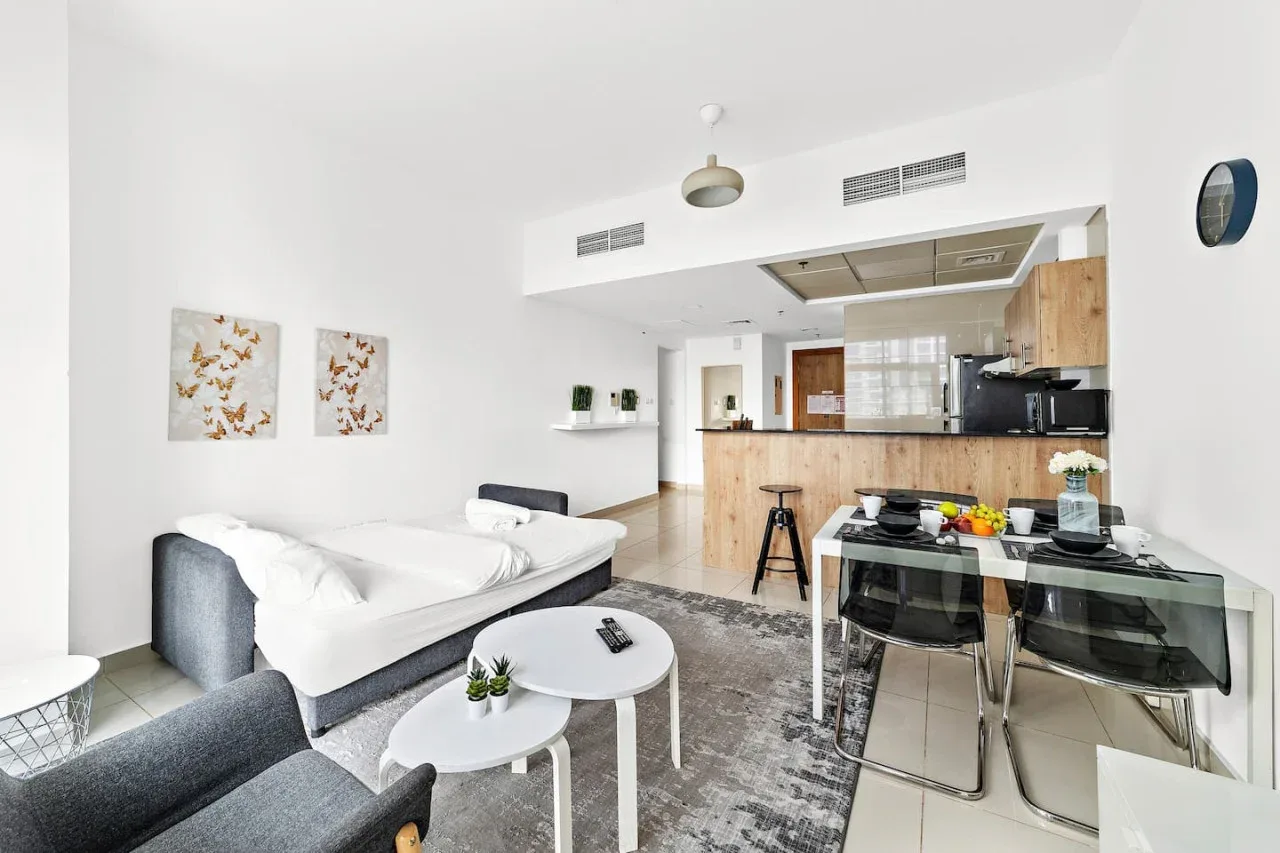 Una luminosa sala de estar de planta abierta conecta una zona de asientos con la cocina y el comedor.