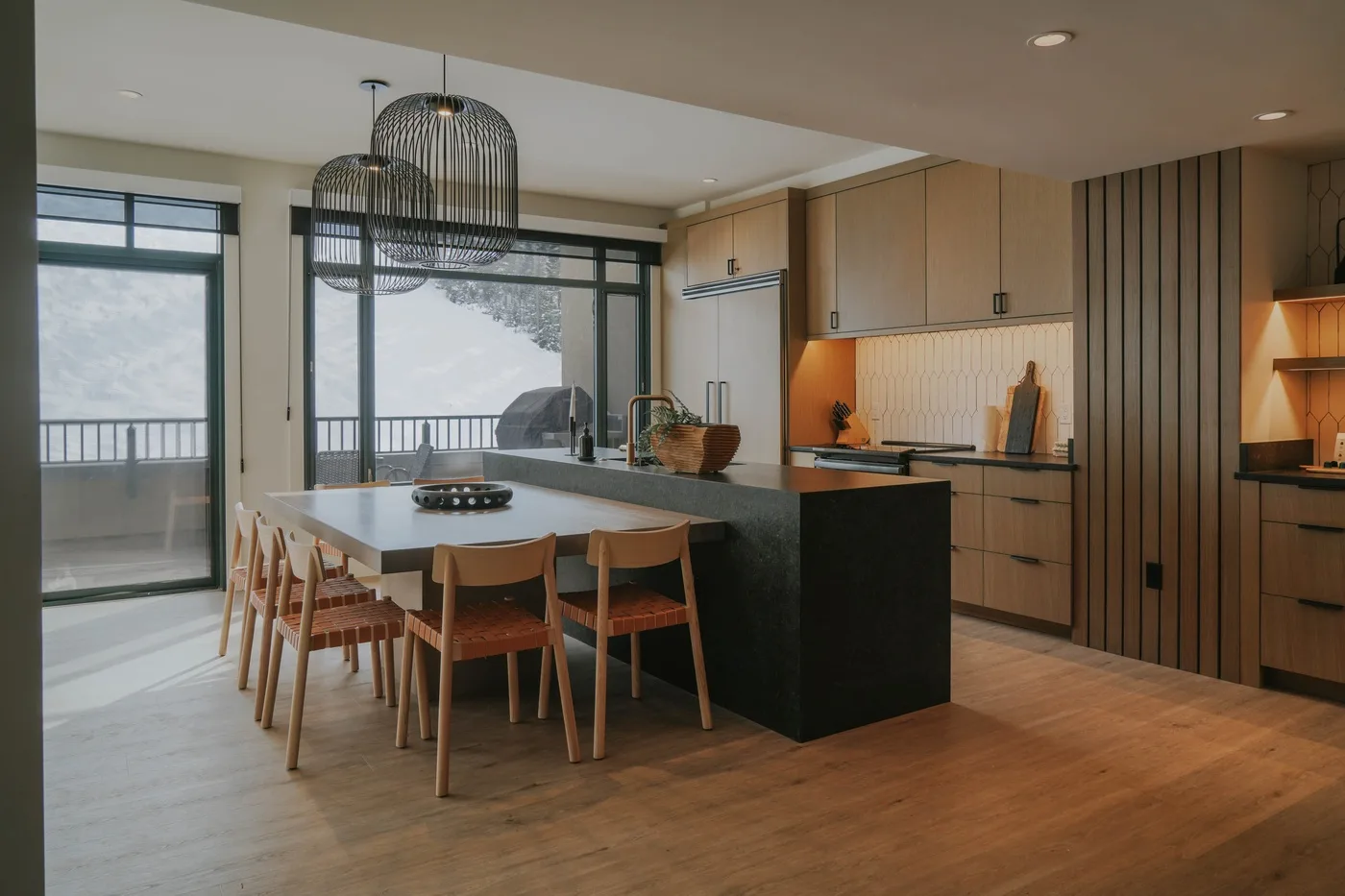 A modern kitchen and dining area with an island and pendant lights.