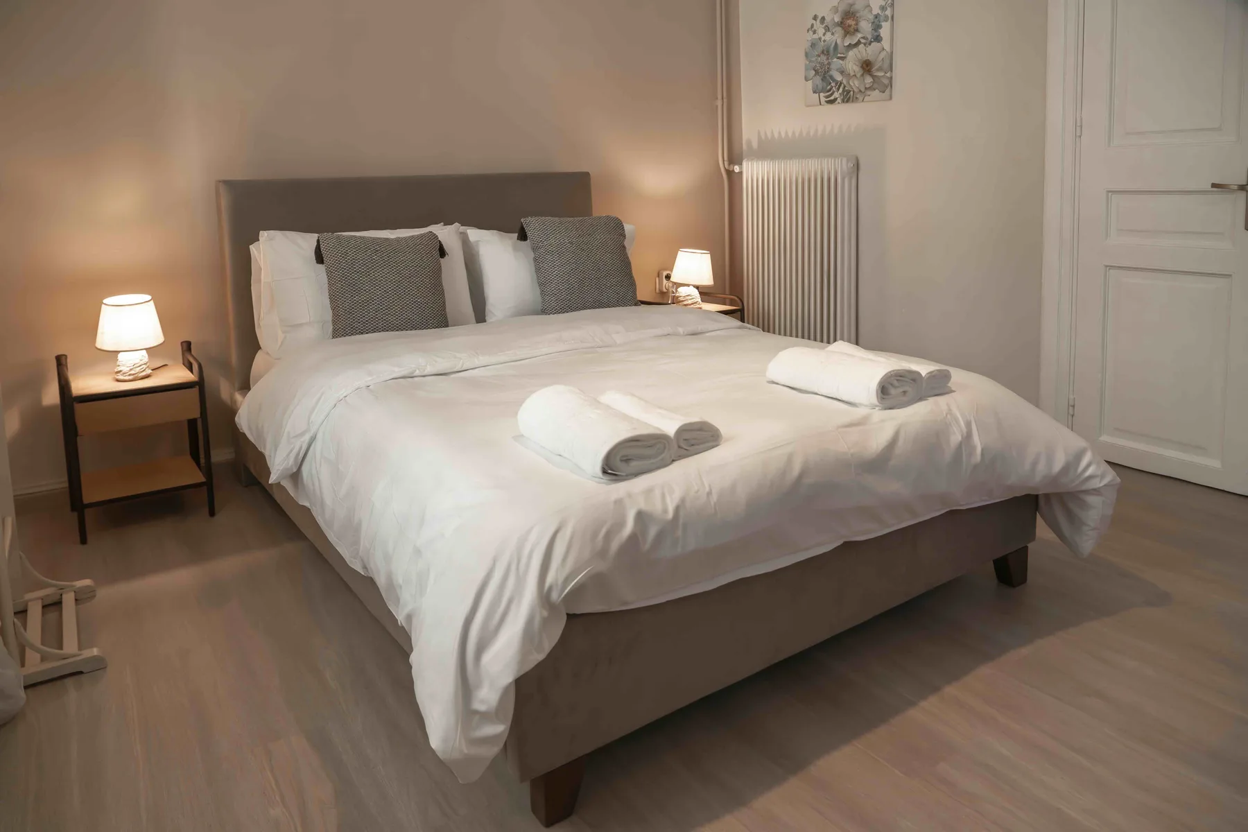 Un dormitorio con una cama bien hecha y mesitas de noche.