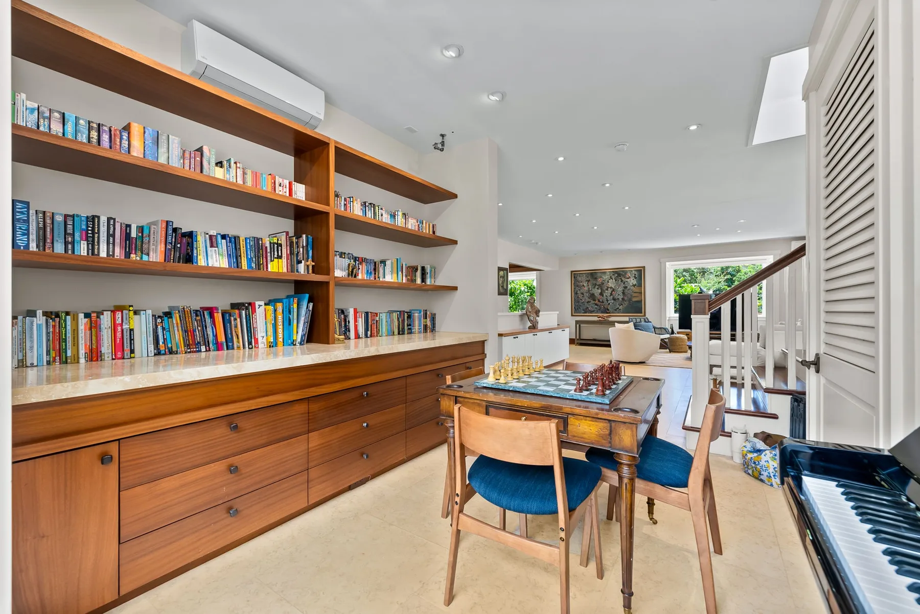 Un comedor luminoso con una mesa de madera y estanterías empotradas.