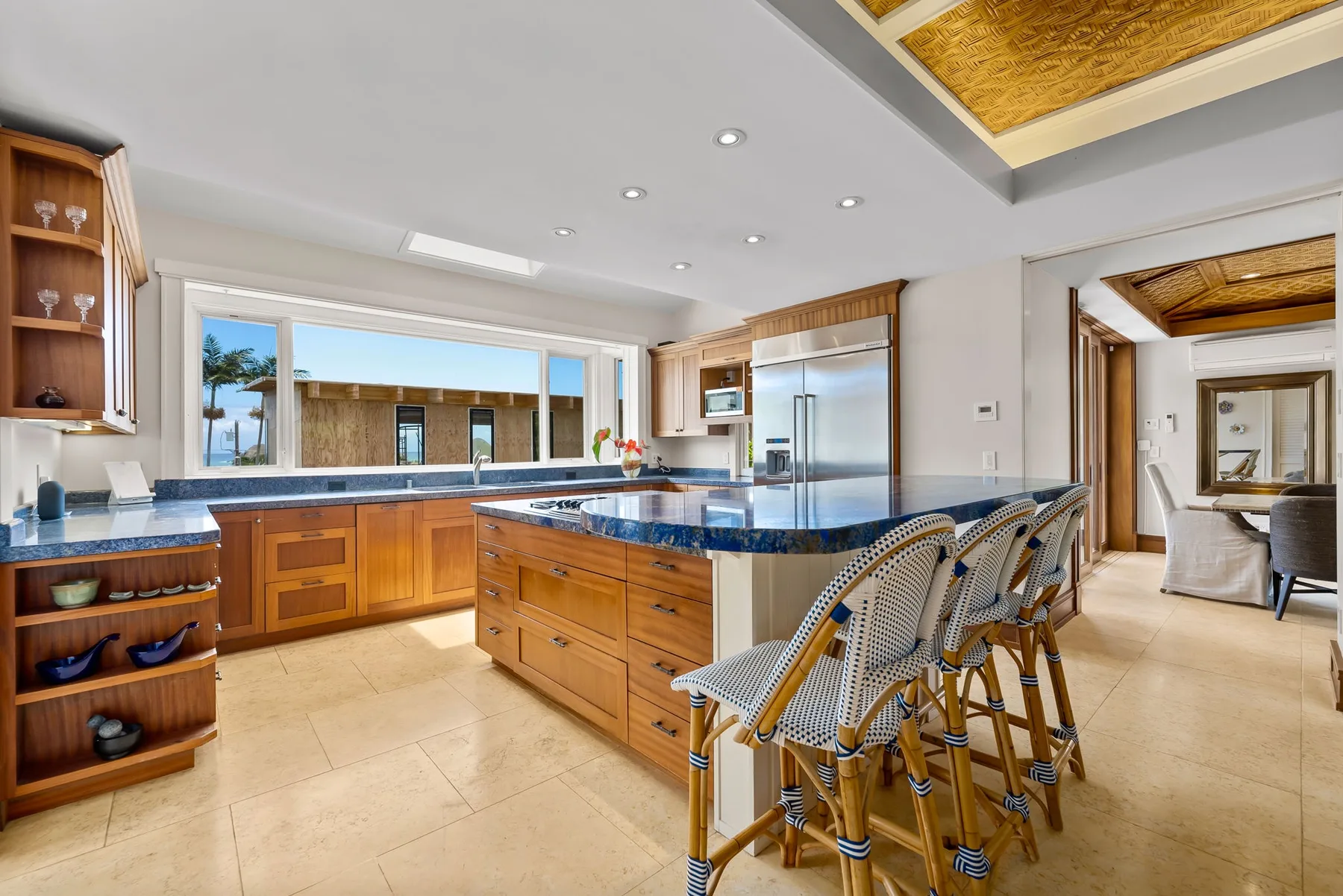 Una cocina luminosa con gabinetes de madera y una isla central con asientos.