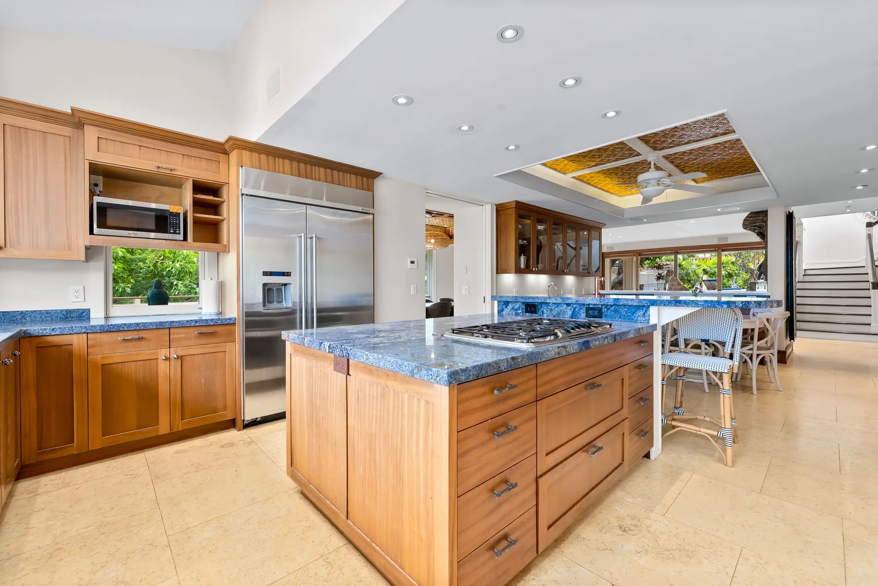 Una cocina luminosa cuenta con gabinetes de madera, una isla central y electrodomésticos de acero inoxidable.