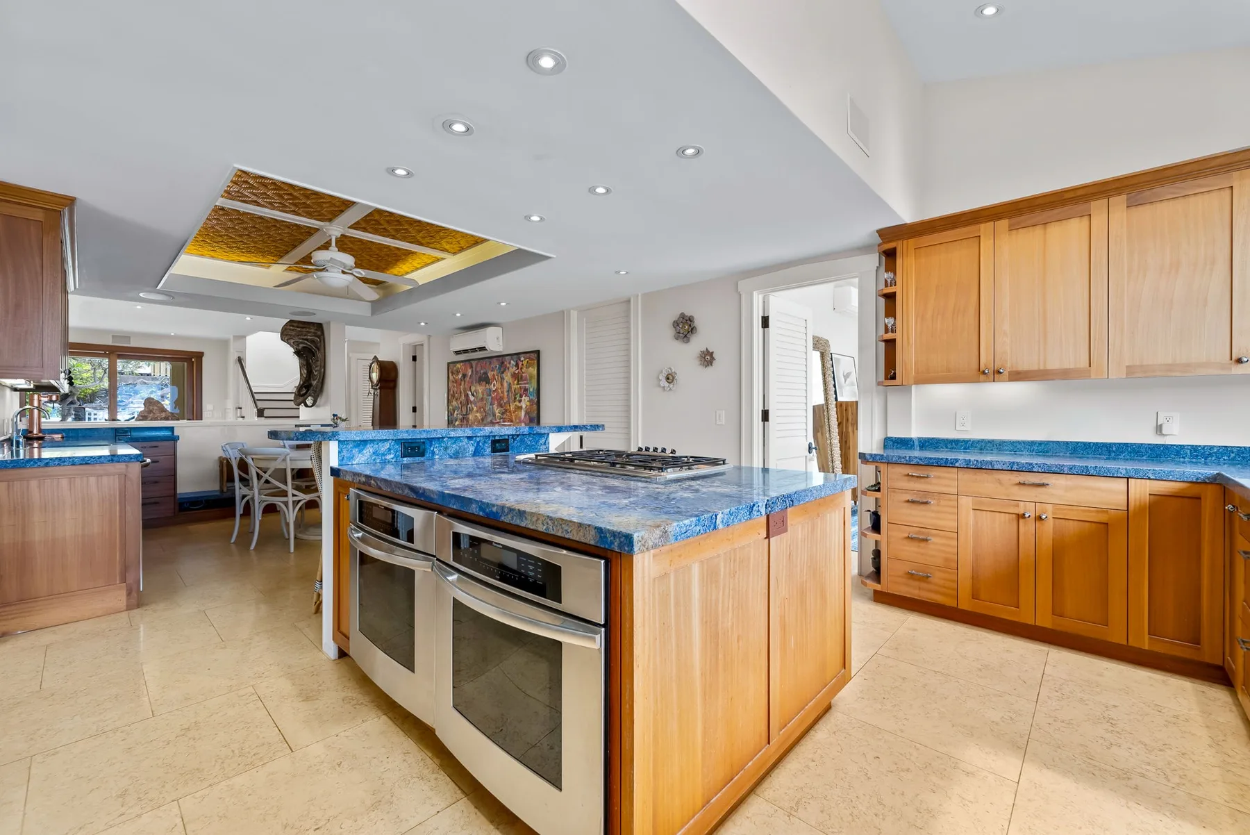 Una cocina amplia con gabinetes de madera y una isla central con superficie de piedra azul.