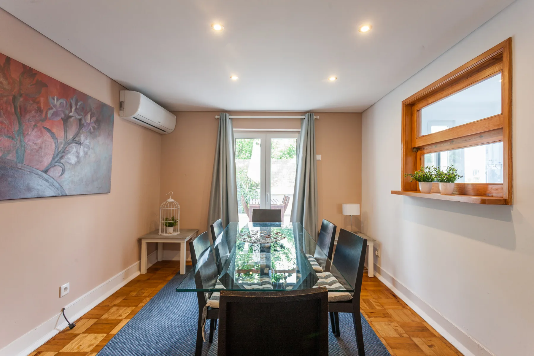 El comedor cuenta con una mesa de vidrio y una ventana amplia.