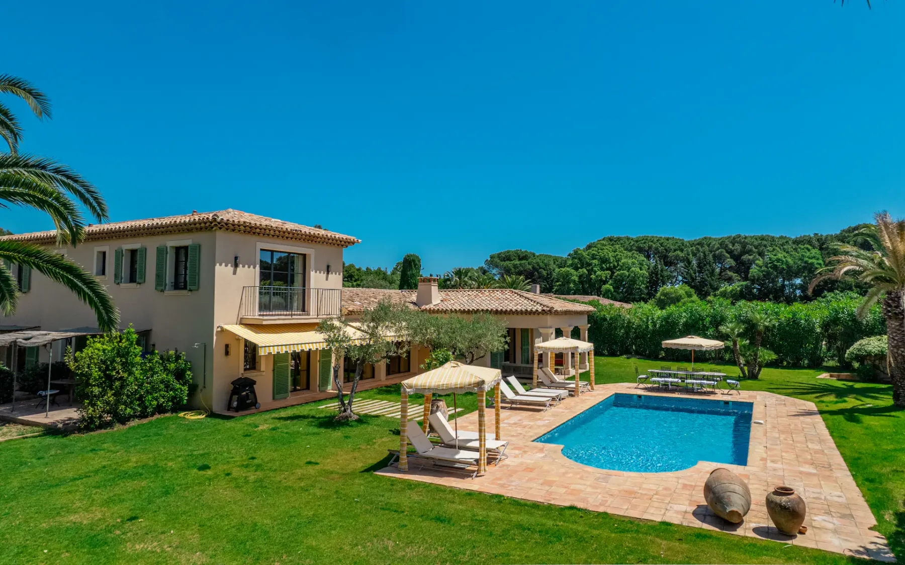 Vista de un gran jardín y una piscina al aire libre detrás de la casa