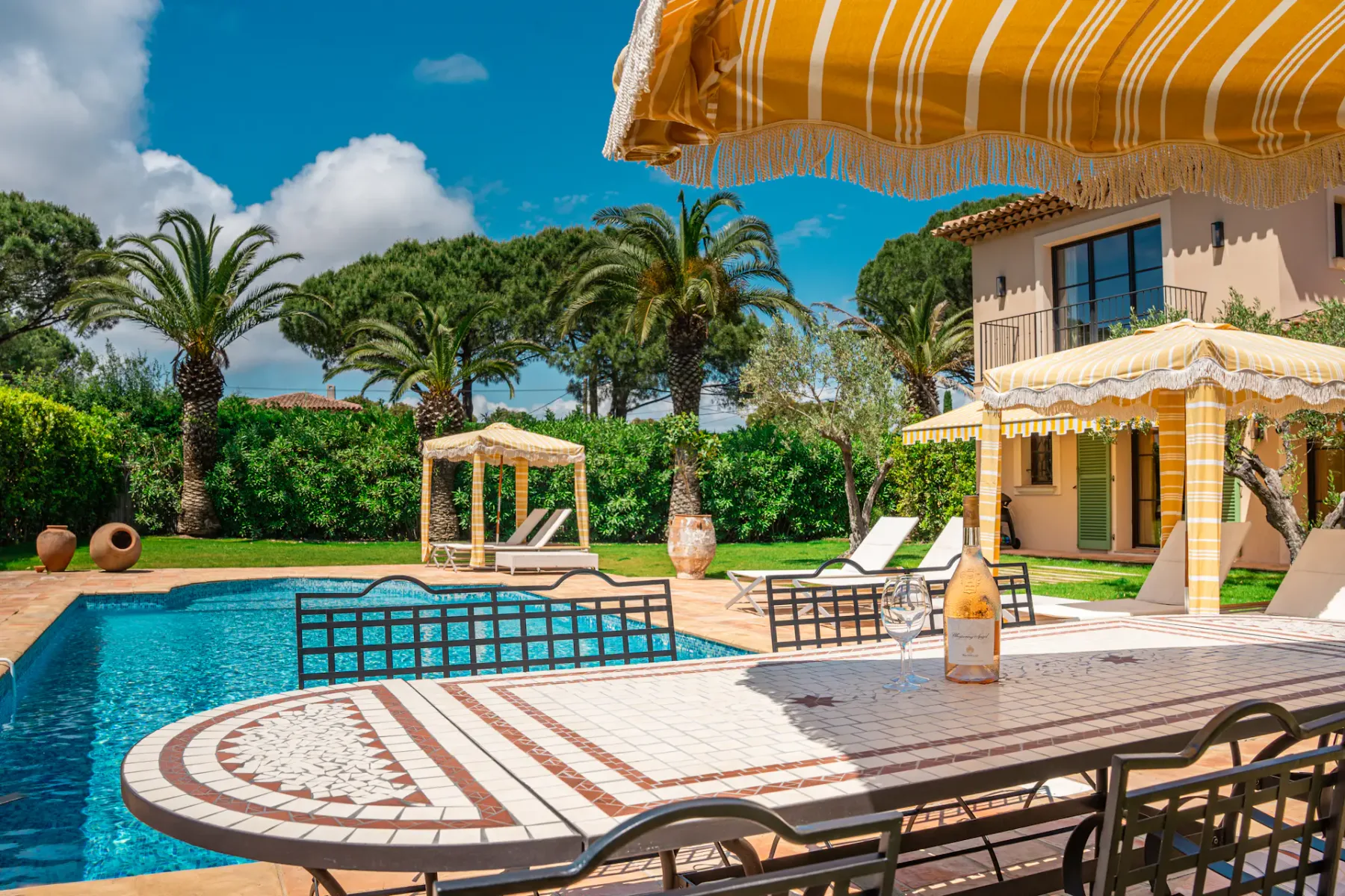 Mesa y sillas en un patio exterior con vistas a una piscina