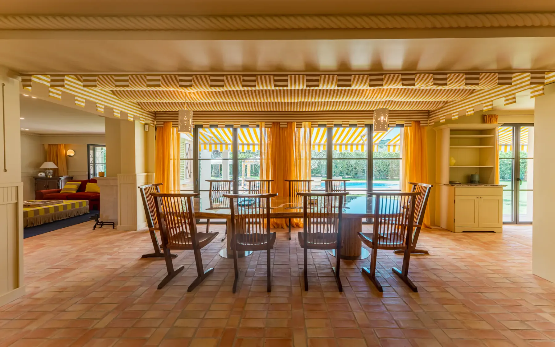 Comedor con mesa y sillas frente a ventanas altas