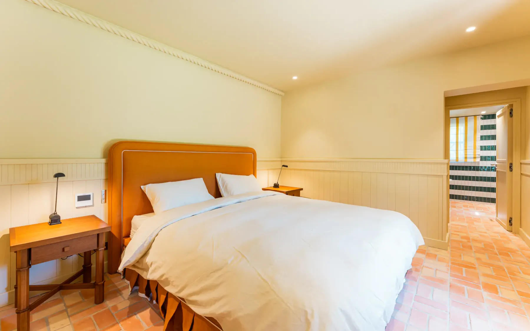 Dormitorio con cama doble y entrada al baño privado al fondo