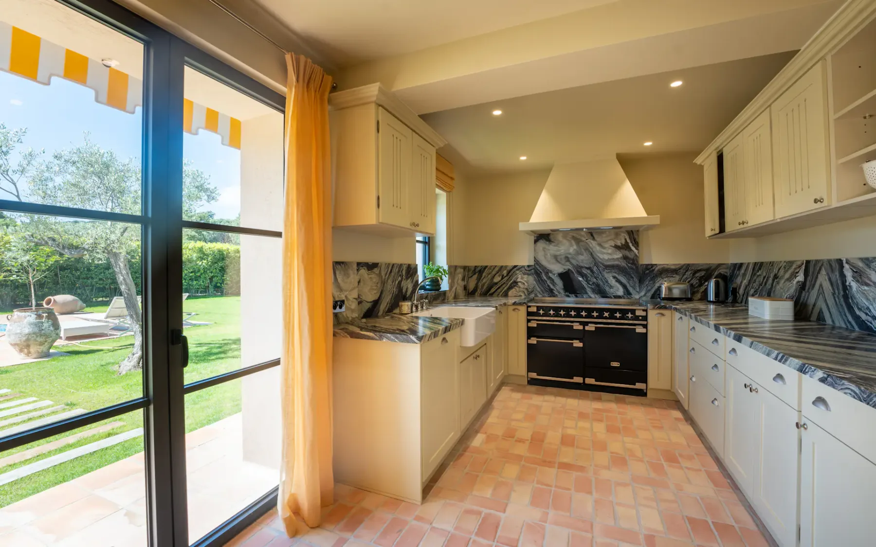 Cocina con puerta corredera de cristal que conduce al jardín exterior