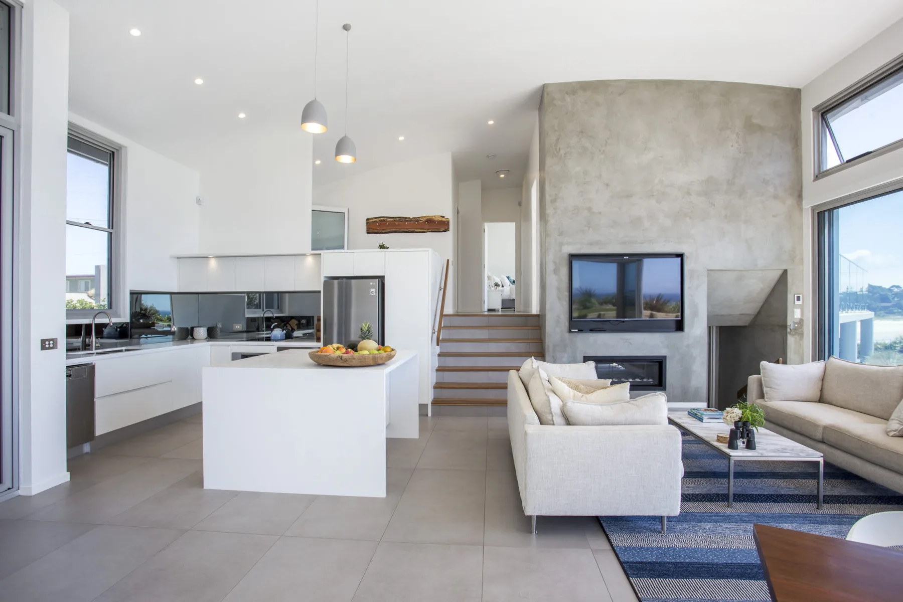 Una luminosa sala de estar y cocina de concepto abierto con chimenea e isla.