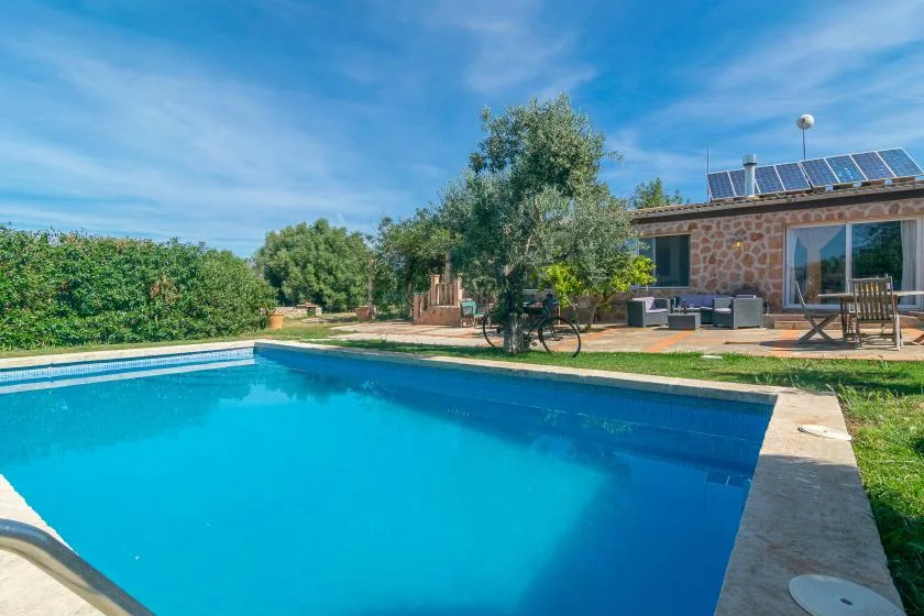 An outdoor swimming pool beside a stone building and patio.