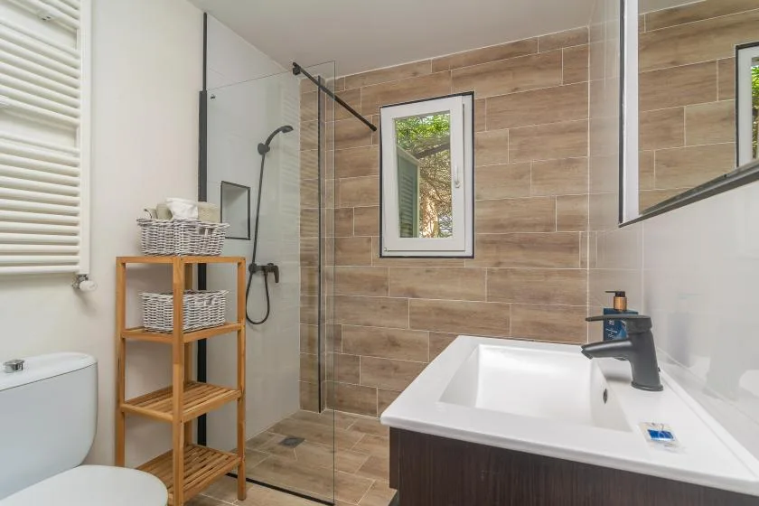 A bathroom with a bathtub, shower, and wood-look wall tiles.