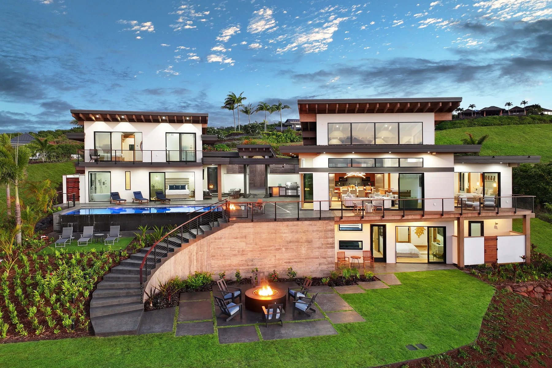 A modern multi-level house with a swimming pool and landscaped grounds.