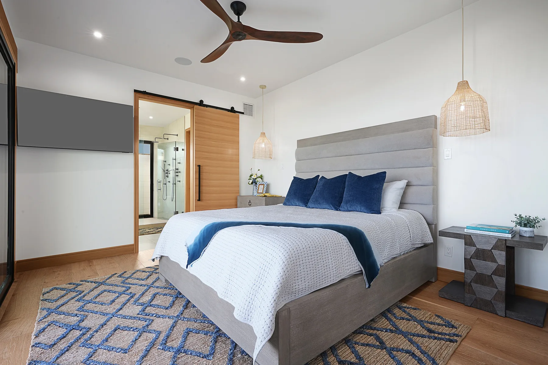 A bedroom with a large bed dressed in white and blue bedding.
