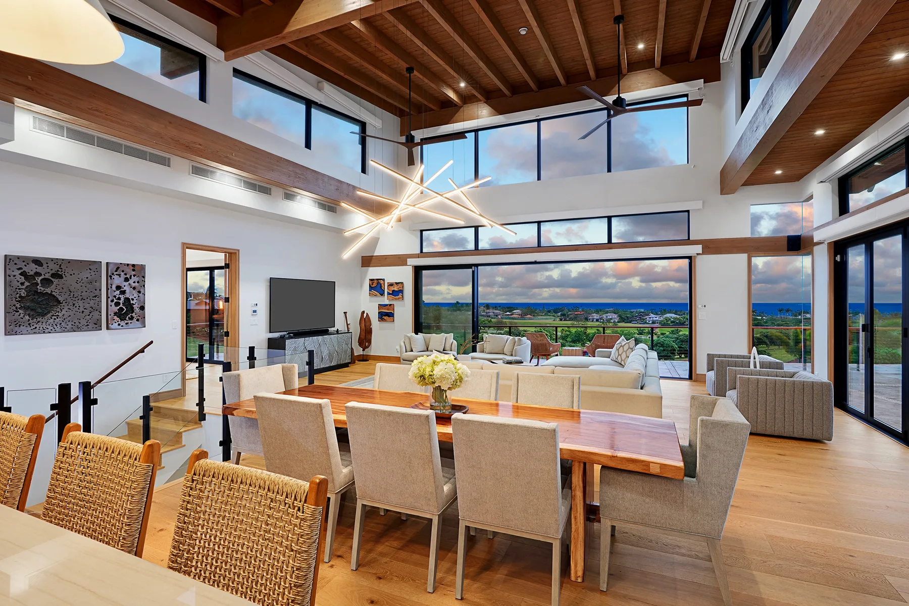 A spacious living and dining area with large windows and a wooden ceiling.