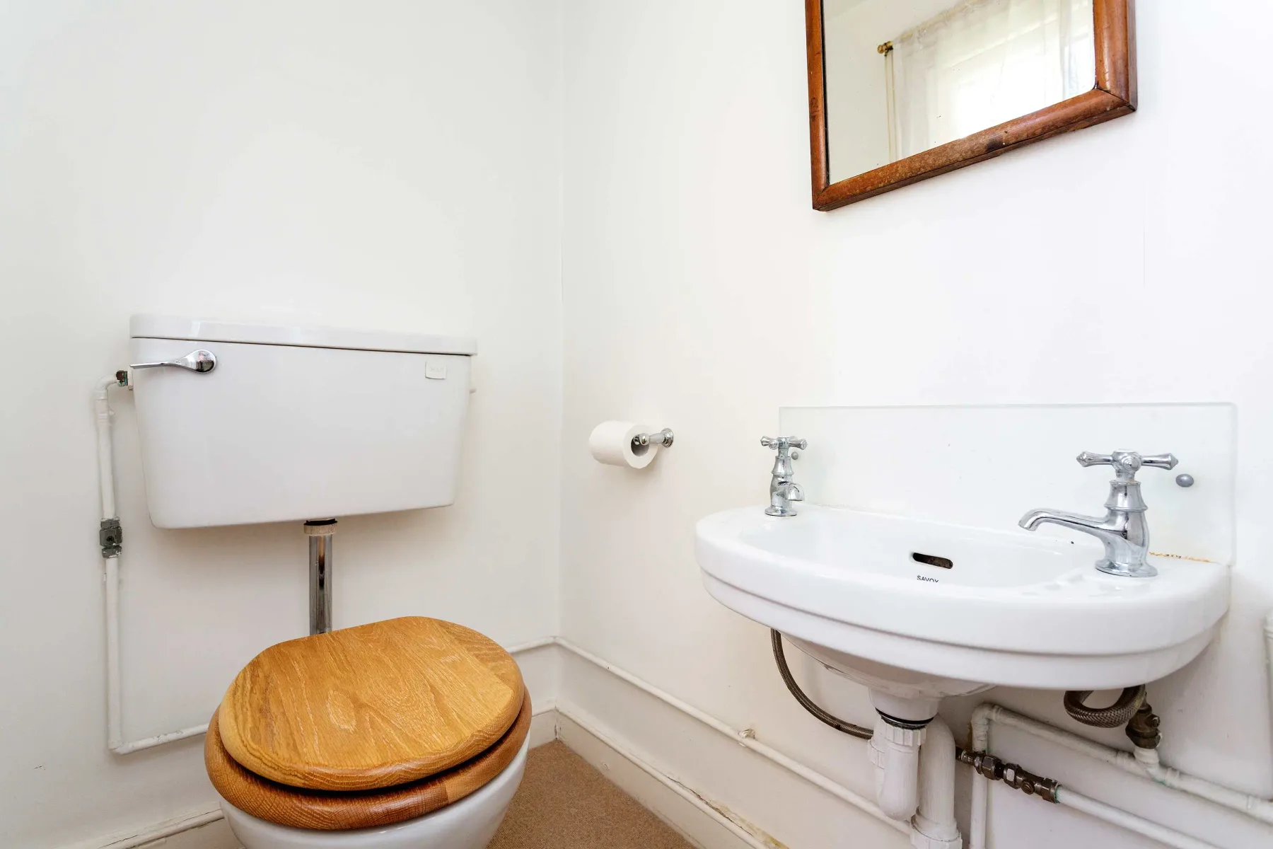 A bathroom with a toilet and wall-mounted sink.