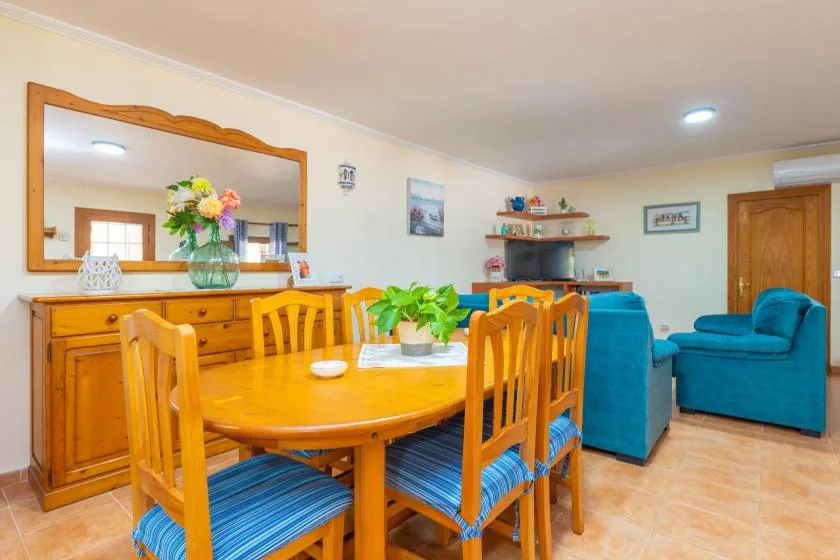 A dining room with a wooden dining table and blue upholstered seating.